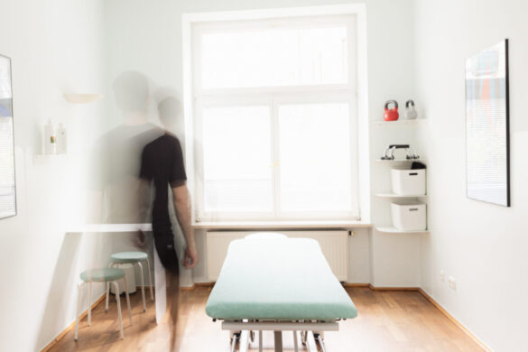 behandlungsraum-physiotherapie-praxis-benedikt-muenchen Heller Behandlungsraum der Physiotherapie Praxis Benedikt München mit Behandlungsliege, Holzboden und inspirierendem Zitat an der Wand