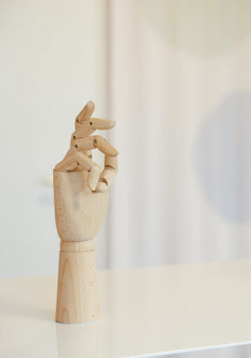 Eine Hand aus Holz räkelt die Finger