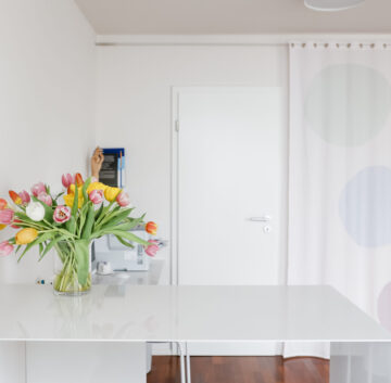 Heller Behandlungsraum mit Blumenstrauß – Praxis Benedikt München